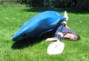 Picture of Mandy Kotzman in an upsidedown whitewater kayak on dryland
