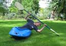 Picture of Mandy Kotzman performing a hipsnap to complete an Eskimo roll of a whitewater kayak on dry land