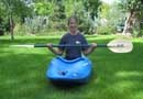 Picture of Mandy Kotzman preparing to flip a whitewater kayak on dry land